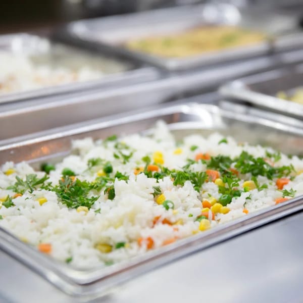Brazilian white rice with corn, peas, carrots, and parsley in a buffet tray at Pampas Grill.